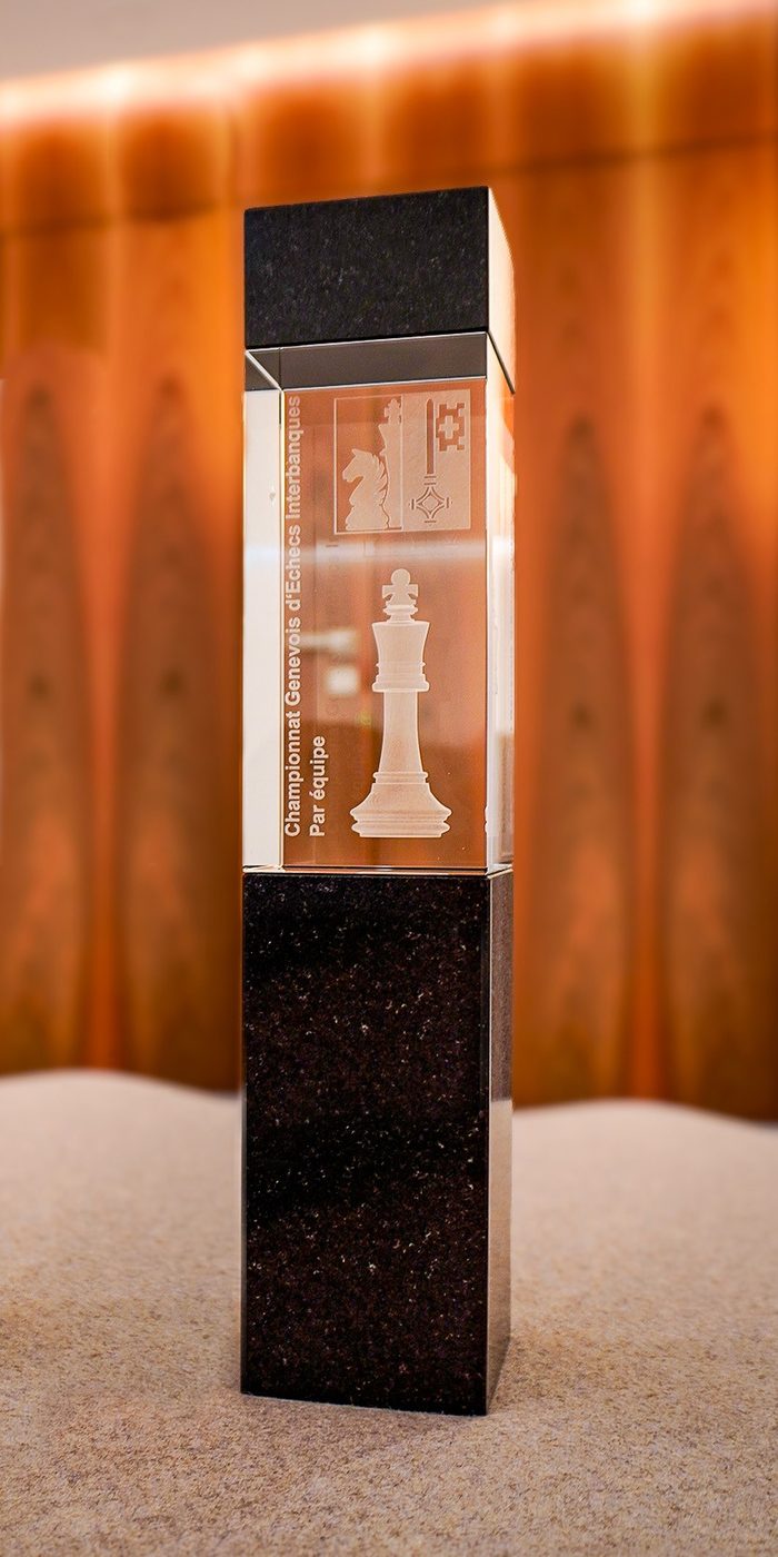 Le trophée par équipe : bloc de verre gravé d'un roi et du logo de l'association, sur un socle de granit